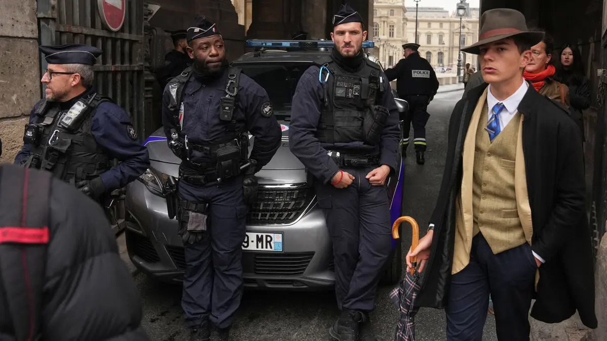 Teenager with hat outside the Louvre steps forward